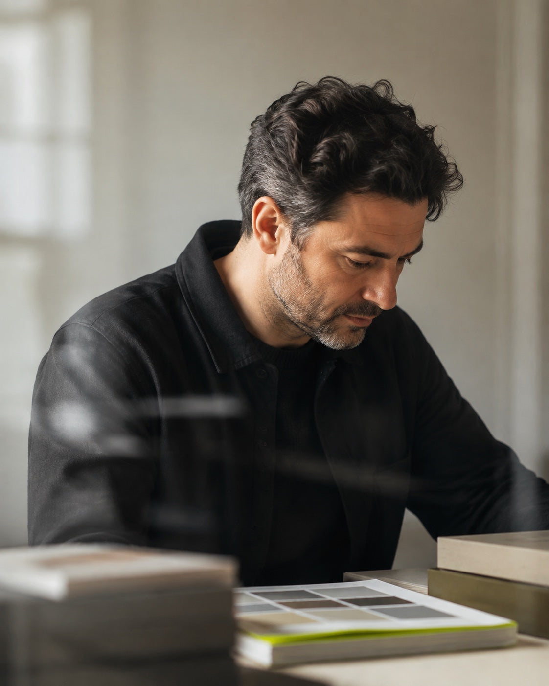 Ecommerce operator reviewing catalogue and packaging work in a daylight studio